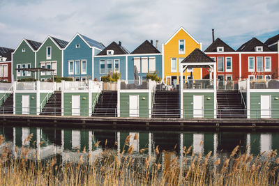 Houses by lake against sky