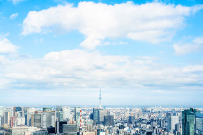 Aerial view of buildings in city against cloudy sky