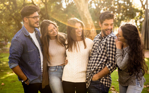 Friends talking while standing at park