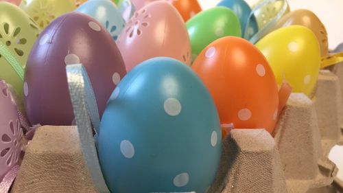 Close-up of multi colored eggs on carton