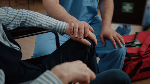 Midsection of man and woman sitting on seat