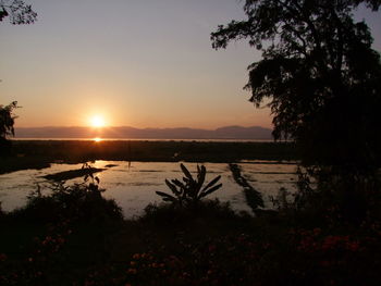 Scenic view of lake against sky during sunset