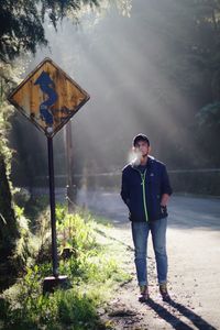 Full length of young man standing by road