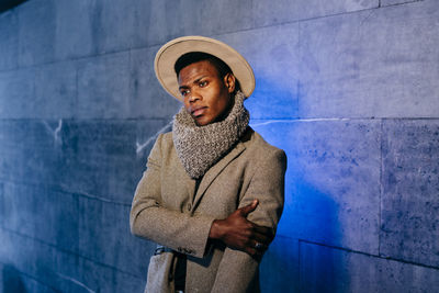 Portrait of mid adult man standing against wall