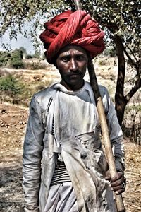 Portrait of man wearing turban while standing on field during sunny day