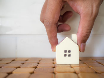 Cropped hand holding model house on table