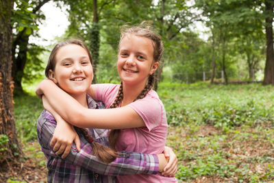 Sisters embracing in forest