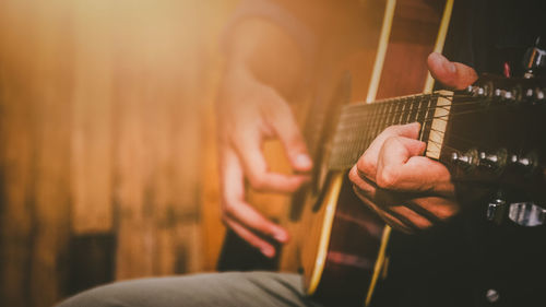 Midsection of man playing guitar