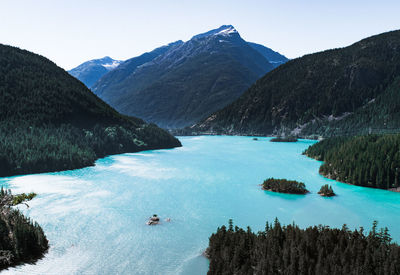 High angle view of lake and mountains against clear sky