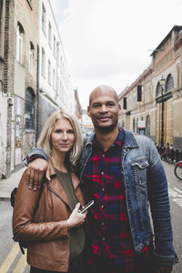 Portrait of loving couple standing on city street