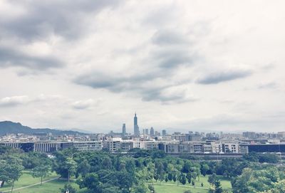 View of cityscape against cloudy sky