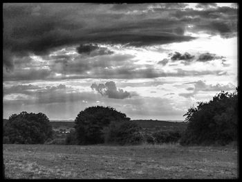 Scenic view of field against cloudy sky