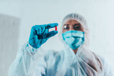 Close-up of woman wearing mask against white background