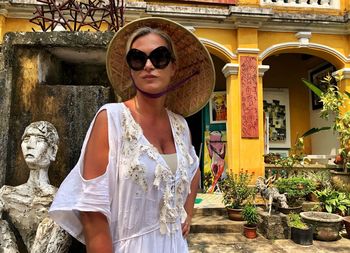 Portrait of woman in hat standing at temple 