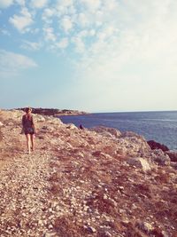 Rear view of young woman walking on beach