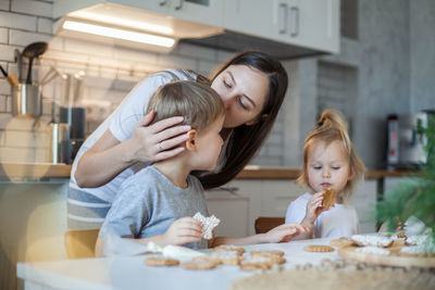 Family making cookies while sitting in kitchen