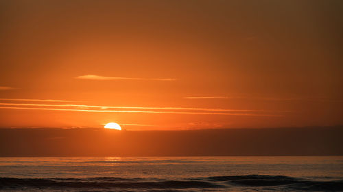 Scenic view of sea against romantic sky at sunset