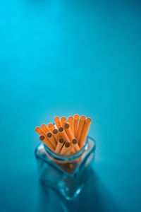 High angle view of multi colored pencils on blue background