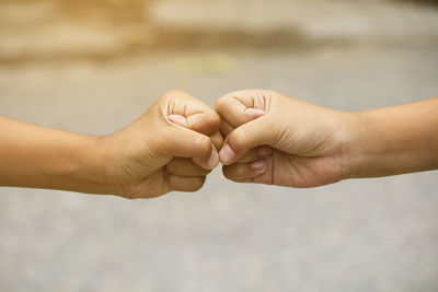 Cropped image of hands fist bumping outdoors