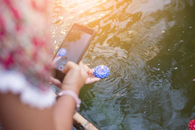 High angle view of woman photographing swimming in water