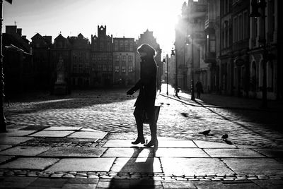 Side view of woman walking on cobbled street