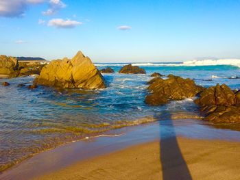 View of rocks on beach against sky