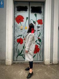 Rear view of woman standing against door