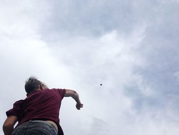 Low angle view of teenager throwing a stone