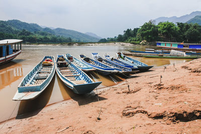 Boats moored on beach against sky