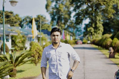 Portrait of man standing against trees