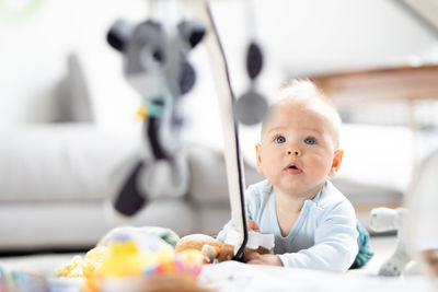 Portrait of cute baby boy sitting on bed at home