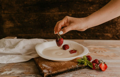 Cropped hand of person preparing food on table