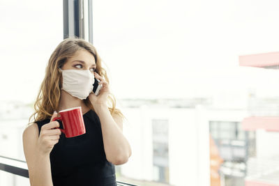 Portrait of young woman drinking coffee