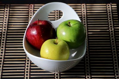 Fresh wet apples in bowl on table