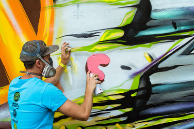 Full length of man wearing multi colored graffiti