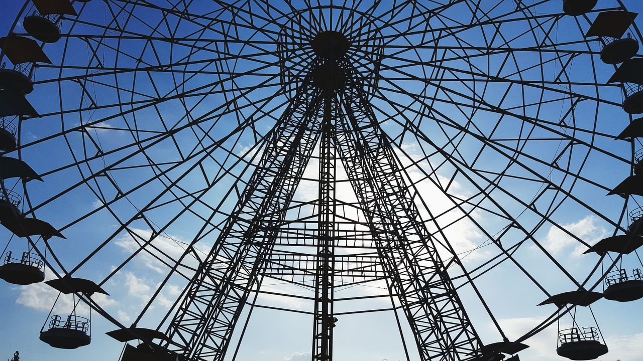 low angle view, sky, amusement park, amusement park ride, architecture, built structure, arts culture and entertainment, ferris wheel, day, metal, nature, no people, outdoors, clear sky, pattern, tall - high, spinning, shape, geometric shape, circle, fairground, directly below, power supply