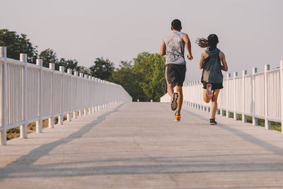 Rear view of people walking on footbridge