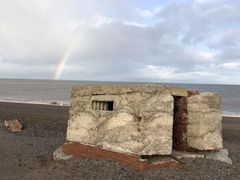 Scenic view of sea against rainbow in sky