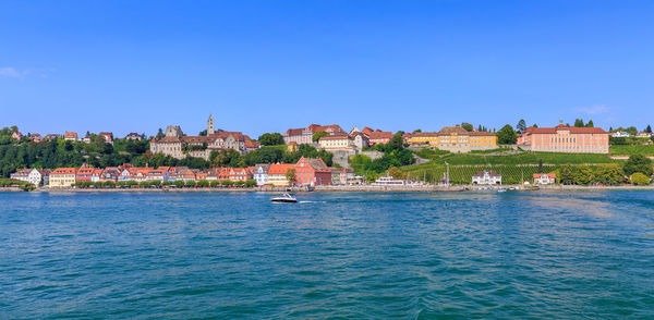 Town by sea against clear blue sky