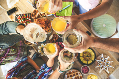 Toast with friends dinner enjoying together friends aperitif  top view of  glasses in hands cheer up