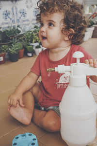 Cute boy looking away while sitting on table