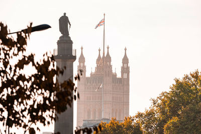 The very symbol of london. westminster abby with uk flag and duke of york monument.