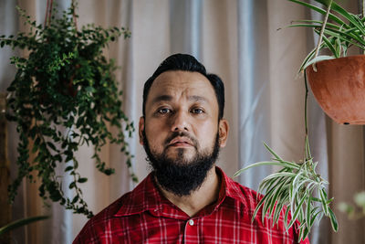 Portrait of man by potted plants