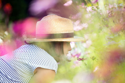 Midsection of woman with pink flowers against blurred background