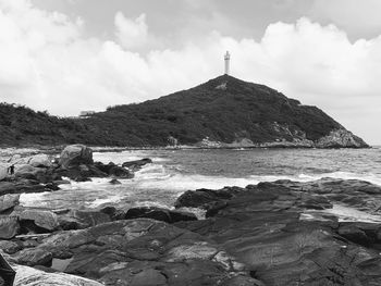 Rock formations on beach against sky