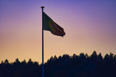 Low angle view of silhouette flag against sky during sunset