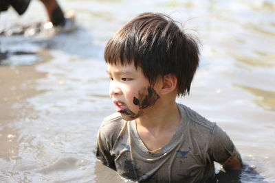 Messy boy in muddy water