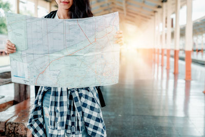 Midsection of woman standing against wall