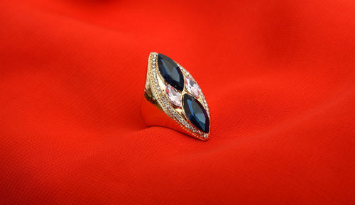 Close-up of ring over red background