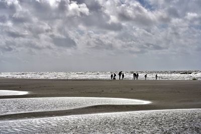 People on beach against sky